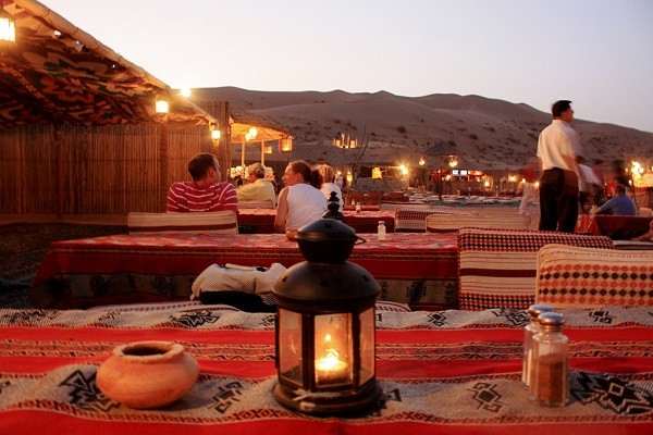 tourists enjoying dune, bashing, camel rides, bbq buffet and private seating on a private desert safari in dubai